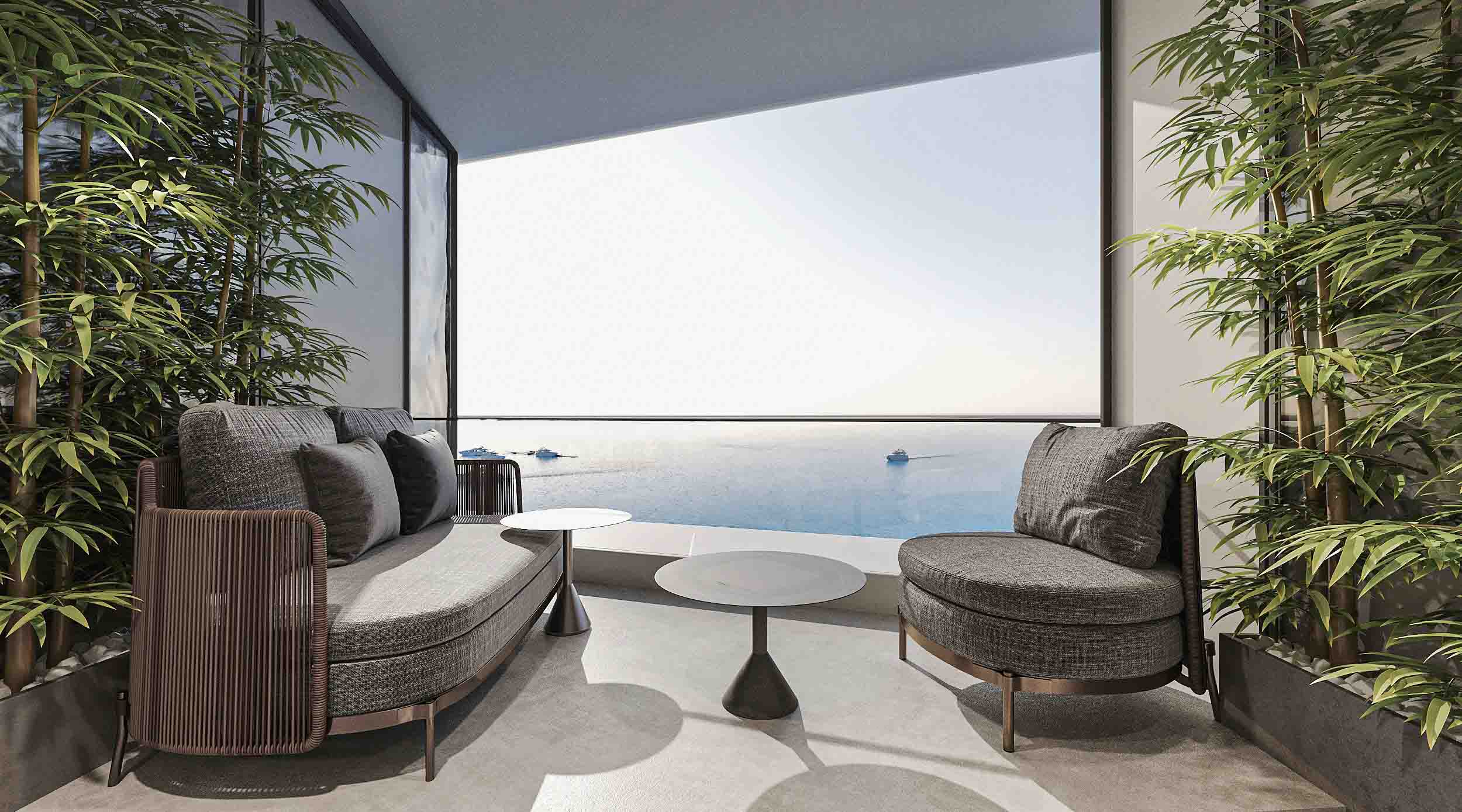 Shaded terrace with designer lounge seating surrounded by tall bamboo and uninterrupted sea views.