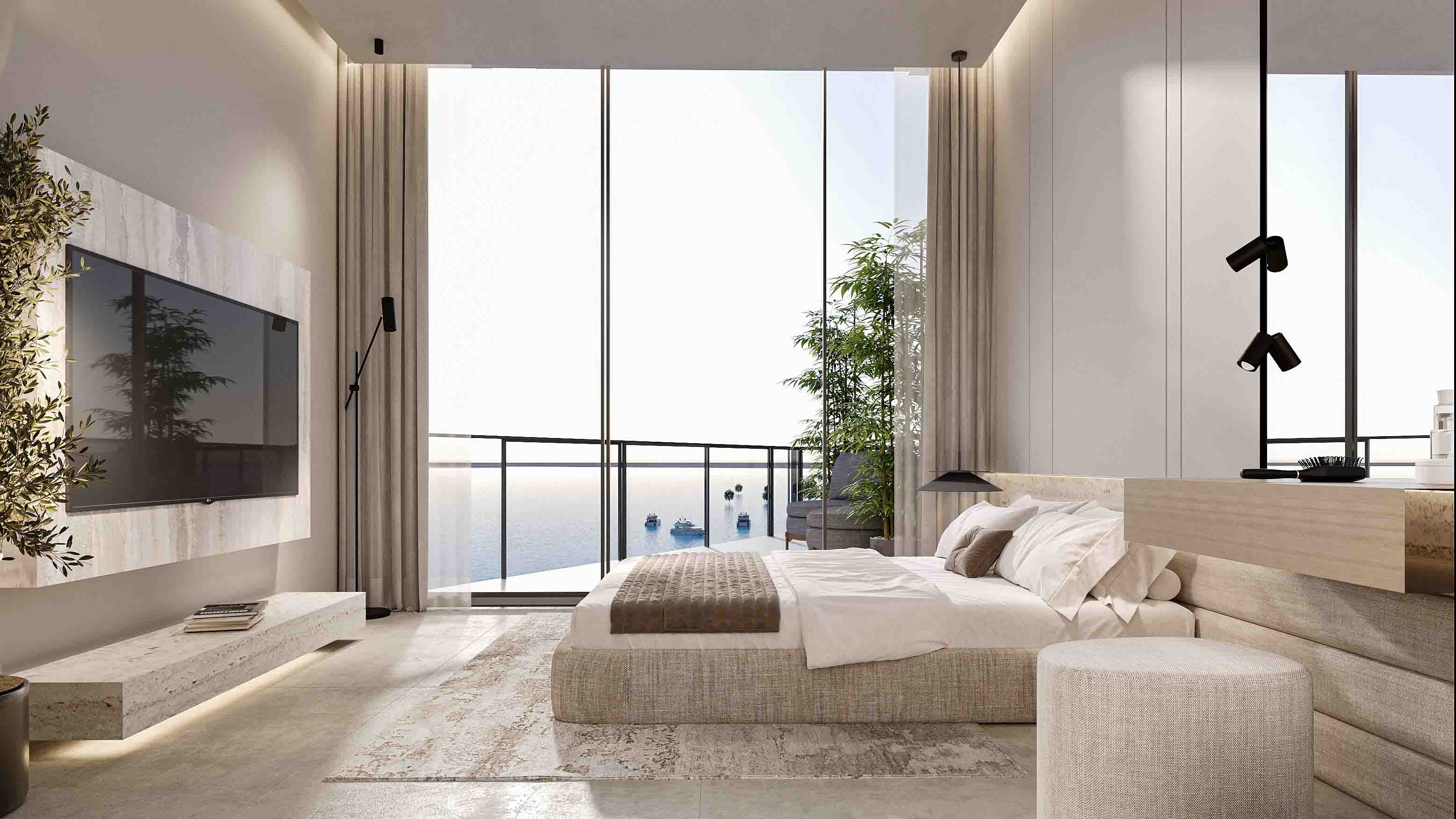Oceanfront bedroom suite with floor-to-ceiling windows, TV wall and cozy seating by the balcony.